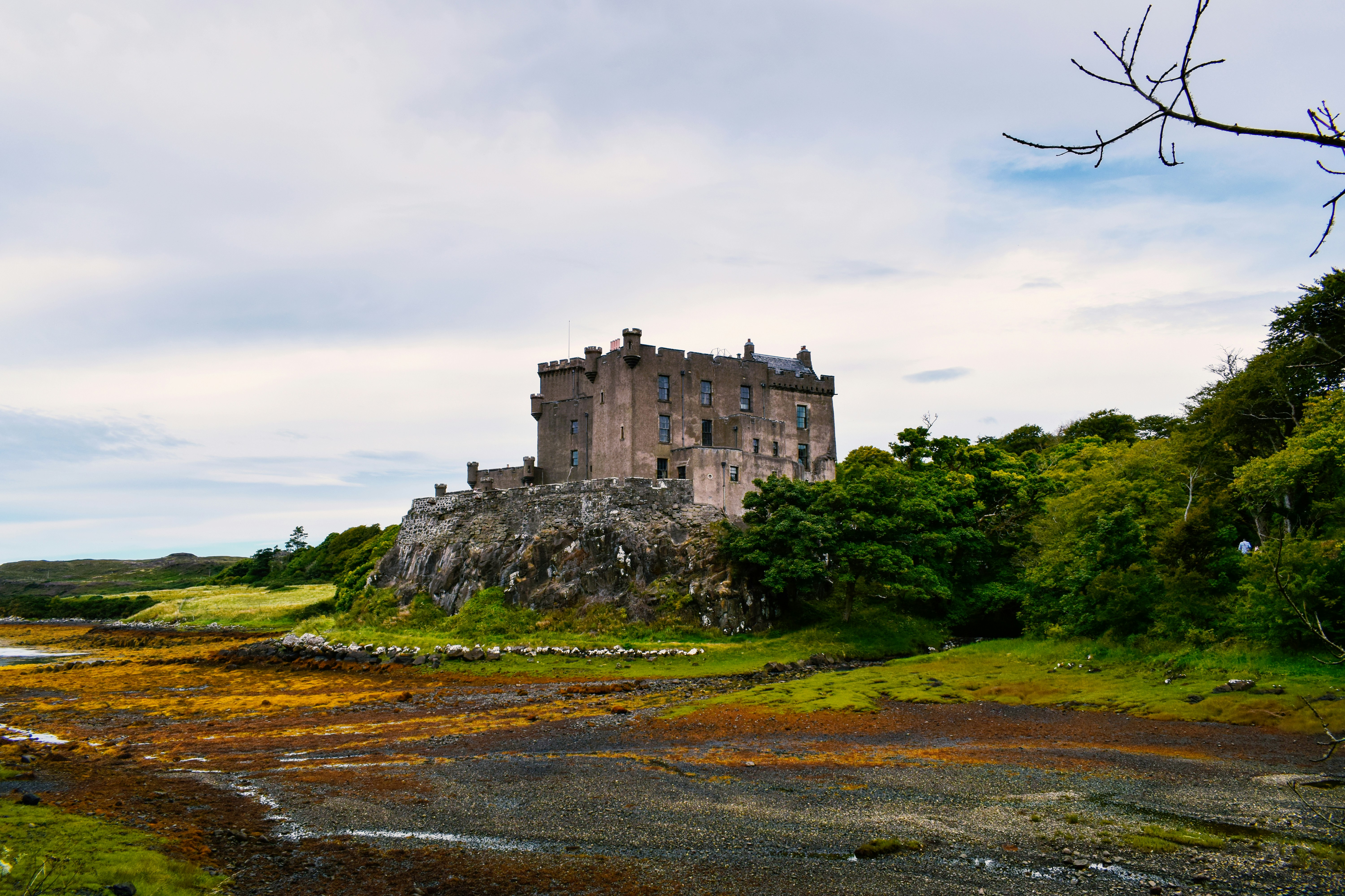 a castle sitting on top of a lush green hillside